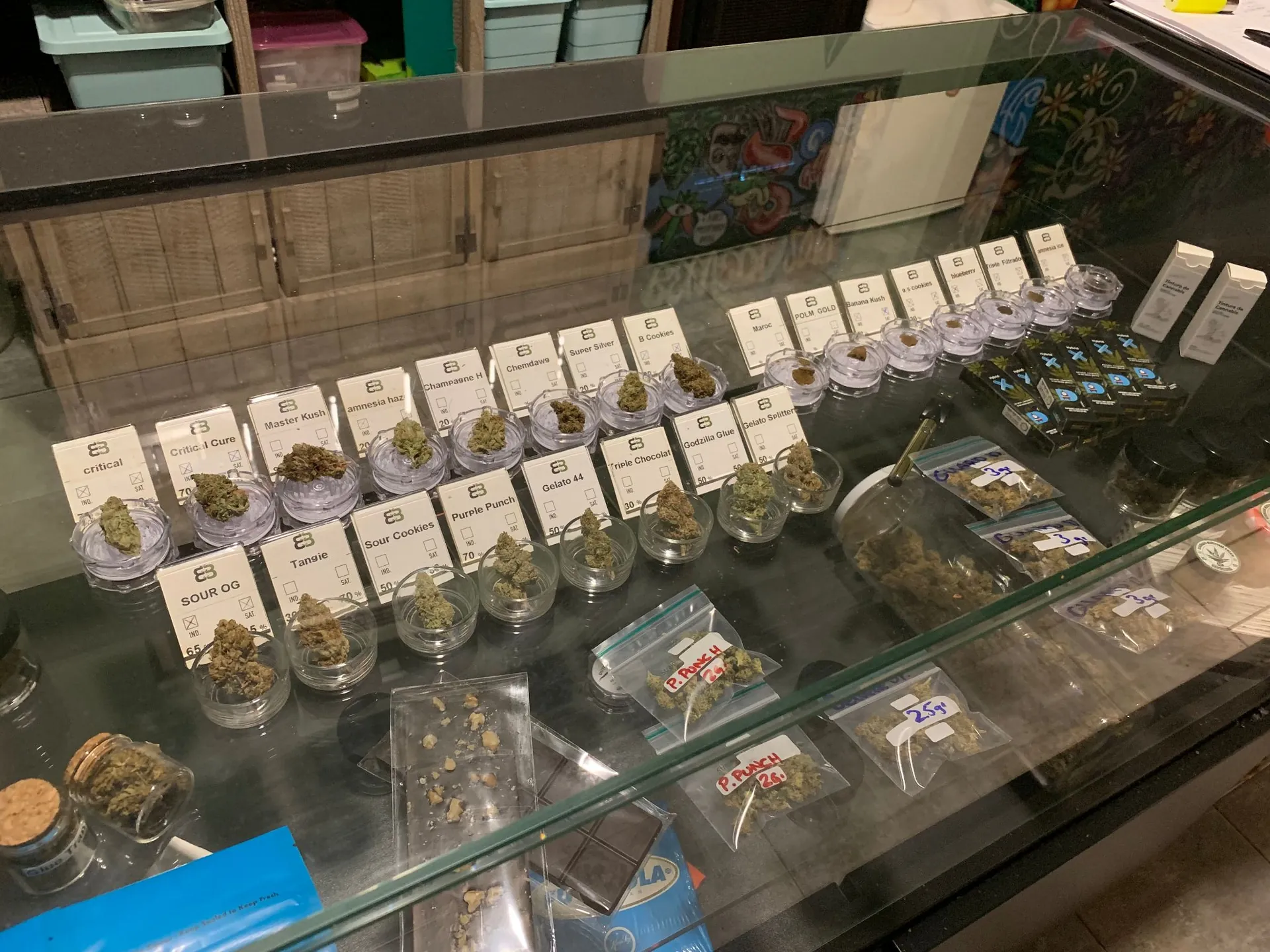 sklenice s různými odrůdami konopí v dispenzáři typu coffee shop
